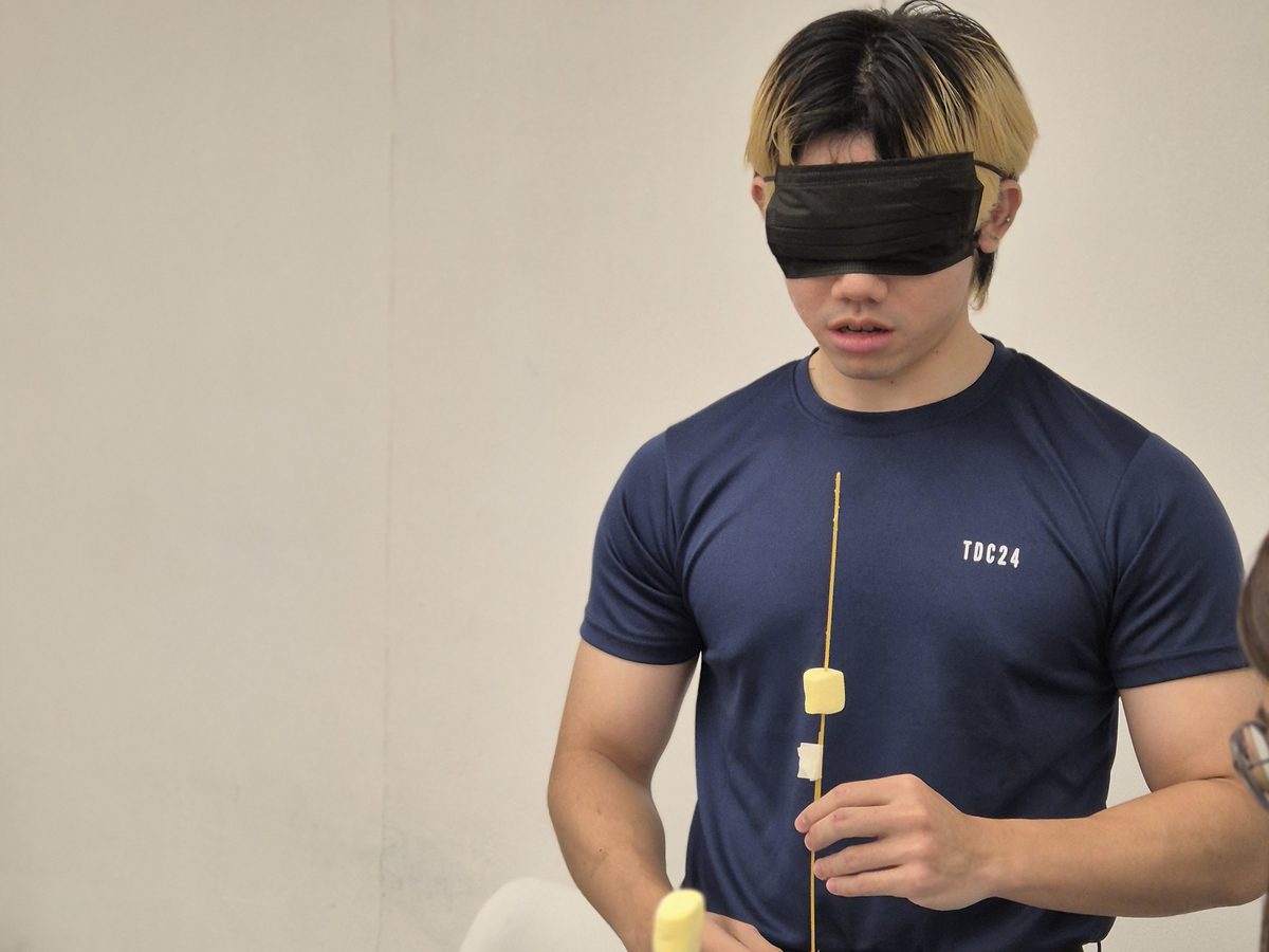 A blindfolded participant building a tower by touch