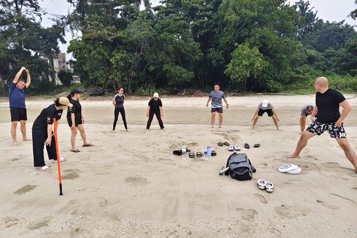 Participants in an outdoor group challenge on the beach