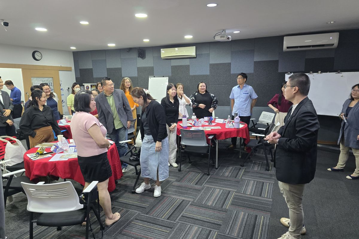 A room of participants on their feet in an activity